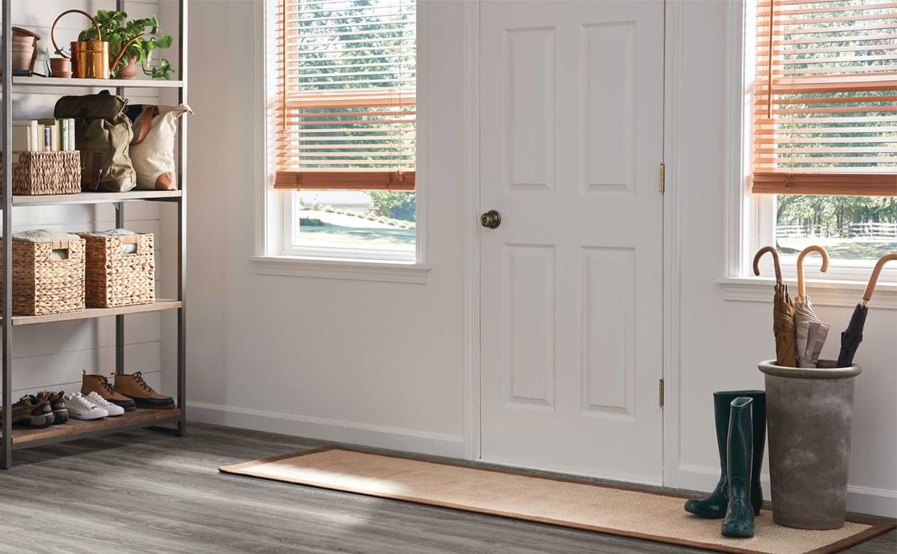 custom wood blinds in entry way by front door with vinyl wood look flooring
